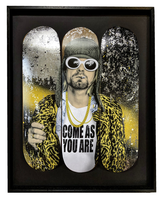 Kurt Cobain skateboard deck with yellow and black spray paint and silver foil for a bold, contrasting design. Skateboard art.